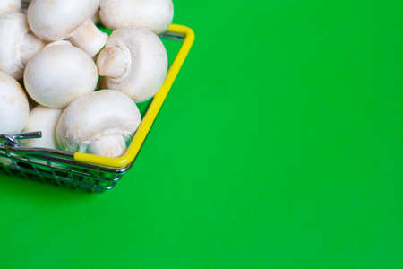 Champignons in a basket on a green background copy spaceの写真素材