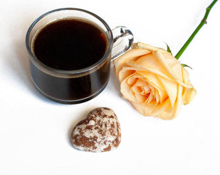 Breakfast coffee chocolate cakes in the shape of hearts and a yellow rose on a white backgroundの写真素材