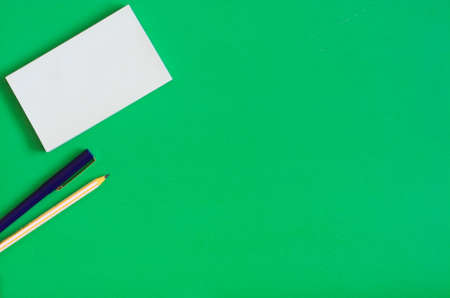 Stationery for notes paper pen pencil green background flat lay copy spaceの写真素材