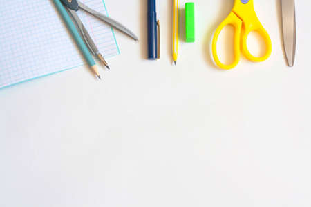 Stationery on a white background notebook pens pencils compasses eraser and scissors flat lay copy space top viewの写真素材