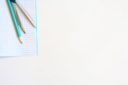Notebook compass and pencil on a white background copy space