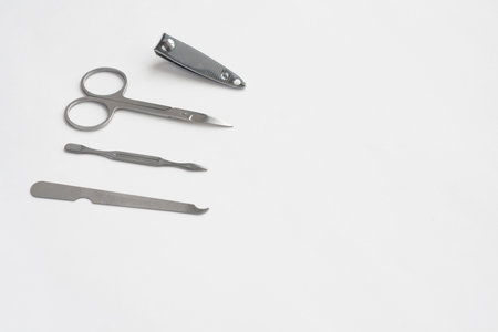 Metal manicure set tweezers scissors file and spatula on white background copy space