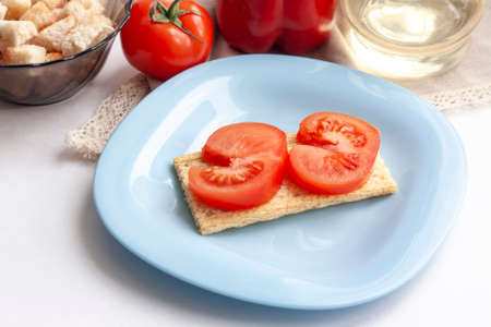 Healthy snack vegetable sandwich on a blue plate tomato bell pepper olive oil and crackers in a bottleの写真素材