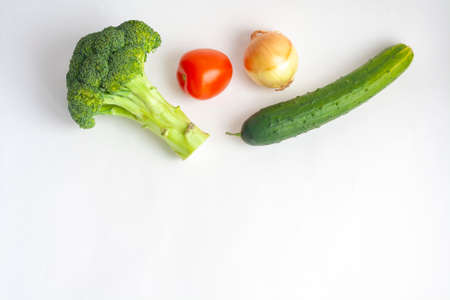 Ripe vegetables broccoli, tomato, cucumber and onion on a white background top view copy spaceの写真素材