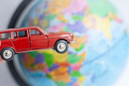 Red toy car on the background of the globeの写真素材