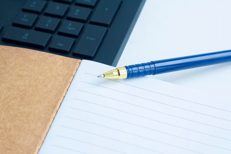 Planning, computer keyboard notebook and blue pen