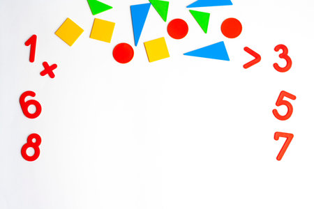 Math geometric shapes of different colors and numbers on a white background flat lay copy spaceの写真素材