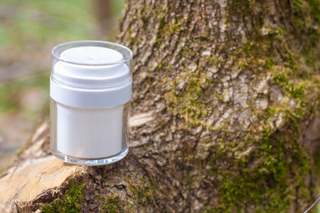 White jar with cosmetics on the bark of a tree in forest