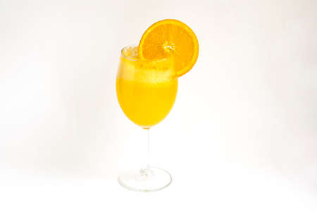 Orange lemonade in a glass with an orange slice, isolated on a white backgroundの写真素材