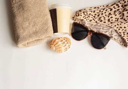 Sunglasses towel shell drink in a paper cup and swimsuit with animal print on a white background flat lay copy spaceの写真素材