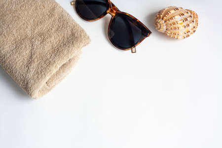 Sunglasses towel and shell on a white background flat lay copy spaceの写真素材