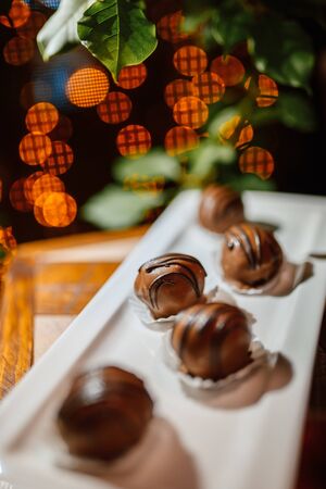 cake with chocolate on a plate with bokeh of lights in the backgroundの写真素材