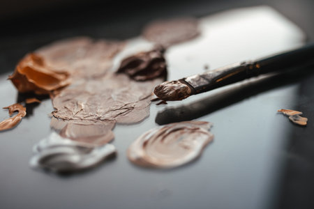 Brush and oil paints of pastel colors on a glossy palette Ñlose-up. palette with mixed oil paints...
