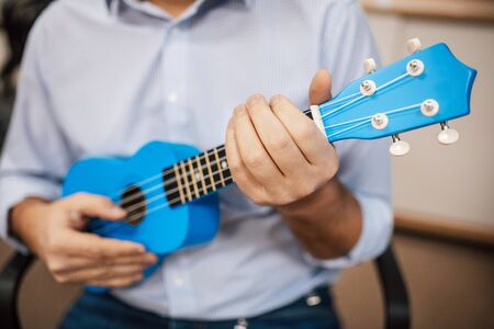 A man playing guitar ukulele in close up viewの写真素材