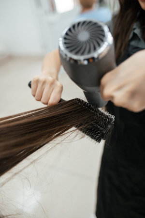 Hairdresser makes hair styling with a hairdryer. Close-up on toolsの写真素材