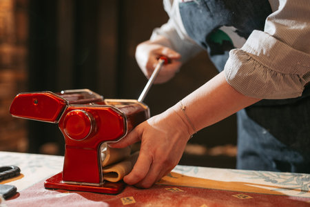 The process of making homemade Italian pasta using a pasta machine. Italian woman preparing homemade...