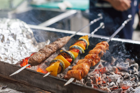 Cooking barbecue on a metal skewer. Mangal with skewered shish kebabs