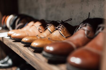 Men's shoe boutique. Brown leather men's shoes stand in a row on a store shelf. Brown Men's Derby in a Store Windowの写真素材