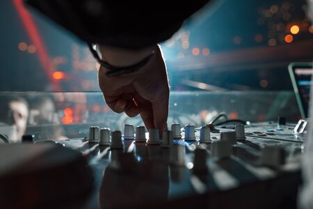 DJ in a nightclub mixing tracks. Hand close-upの写真素材