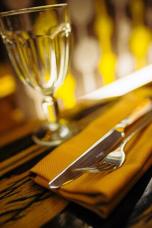 blurred tÐµable setting in a restaurant. Fork and knife close up, warm brown tintedの写真素材