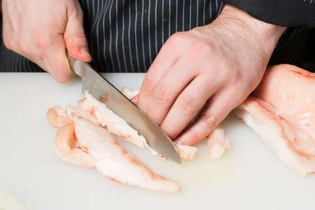 Step-by-step process and stages of cooking oriental cuisine - pilaf. The cook cuts on a cutting board carrots for pilafの写真素材