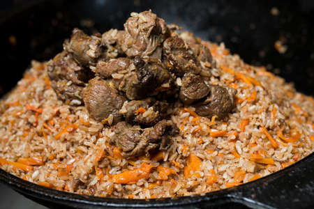 Step-by-step process and stages of cooking oriental cuisine - pilaf. The cook cuts on a cutting board carrots for pilafの写真素材