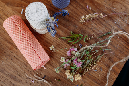 DIY decorative wax candles, scissors and twine on wooden table