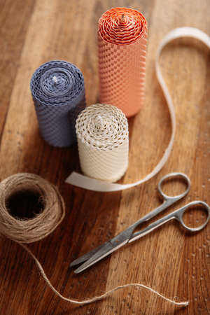DIY decorative wax candles, scissors and twine on wooden tableの写真素材