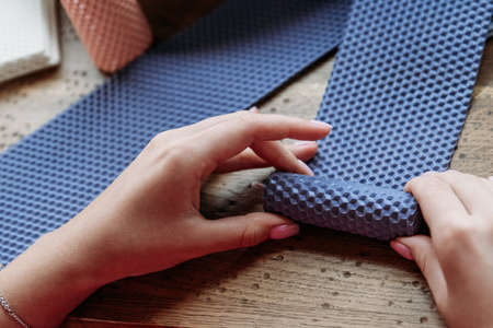 DIY wax candle making process. Woman making decorative wax candle, close-up of handsの写真素材