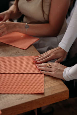 DIY wax candle making process. Woman making decorative wax candle, close-up of handsの写真素材