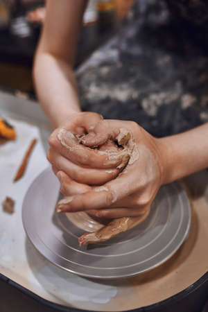 Women working on potters wheel making clay objects in pottery workshopの写真素材