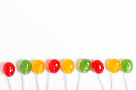 multicolored lollipops on a white background. concept of bad sweets. candy concept for kids. copy space, minimalism.の写真素材