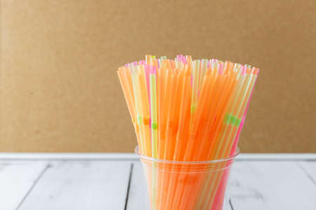 Colorful drinking straws in a plastic cup. The problem of environmental pollution.の写真素材