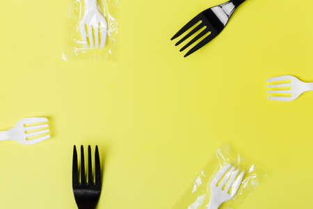  White and black plastic forks on a yellow background. The global problem of environmental pollution. Copy space. flat lay minimalism の写真素材