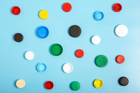 Multi-colored plastic bottle caps on a blue background. The problem of environmental pollution. Top view, Pattern. Recycling plastic.の写真素材