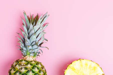 Fresh ripe pineapple and sliced pineapple on a pink background. summer concept. copy space, minimalism, flat lay, top view.の写真素材