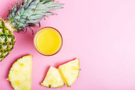 Fresh ripe pineapple, sliced pineaplle and a glass of juice. hot summer concept. copy space, minimalism, flat layの写真素材