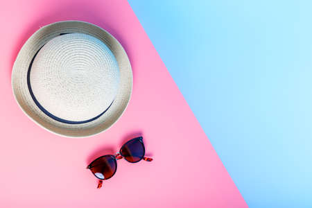 straw hat and sunglasses on a pink and blue background. summer and beach vacation concept. flat lay, copy space, minimalism.の写真素材