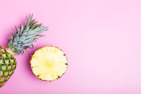Fresh ripe pineapple and sliced pineapple on a pink background. summer concept. copy space,...