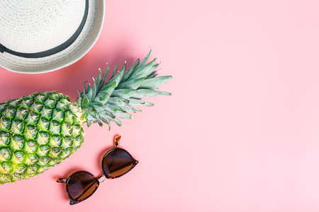 pineapple, straw hat and sunglasses on a pink background. summer concept. flat lay, top view, copy space, minimalism.の写真素材