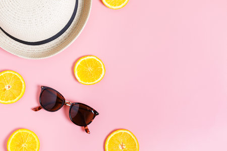 Sliced ââorange, glasses and hat on a pink background. Summer concept. Top view, flat lay, copy space.の写真素材