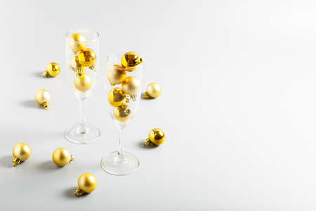 champagne glasses and golden christmas balls on gray background. New Year or Christmas concept.の写真素材