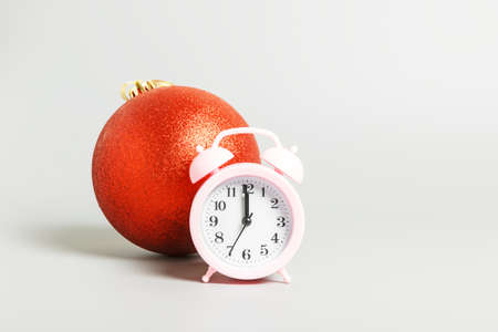 pink alarm clock and red christmas ball on a gray background. Christmas or new year concept. copy space, minimalismの写真素材