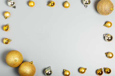 frame of gold and silver Christmas balls on a gray background, Christmas background. New Year or Christmas decorations. top view, flat layの写真素材