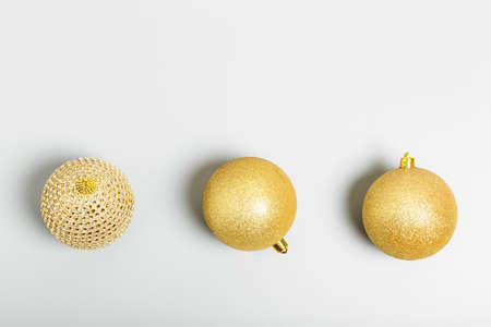 three golden christmas balls on gray background. New Year or Christmas concept. top view, copy space, minimalismの写真素材