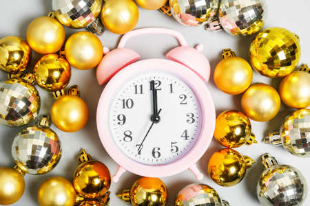 pink alarm clock and golden christmas balls. midnight on New Years or Christmas night. New Year or Christmas celebration concept. top view, flat lay.の写真素材