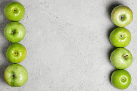 Green apples on a gray concrete background. Harvest apples, summer season, fresh fruits. Top view, flat lay, copy space.の写真素材