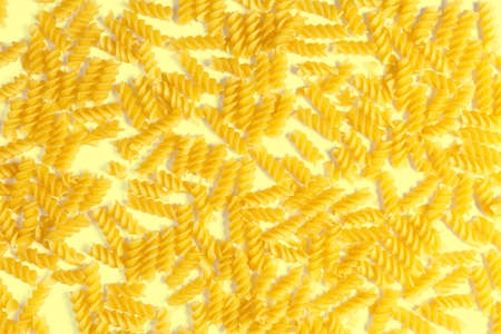 raw fusilli pasta on a yellow background. Top view.の写真素材