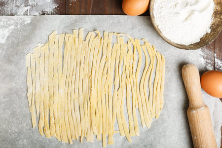 the process of making homemade pasta. pasta cut from dough on cooking paper, flour, eggs, rolling...