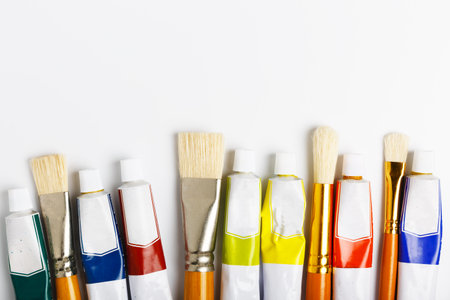 paint brushes and tubes with oil paint on a white background. concept of drawing school, art store. copy space, flat lay.の写真素材